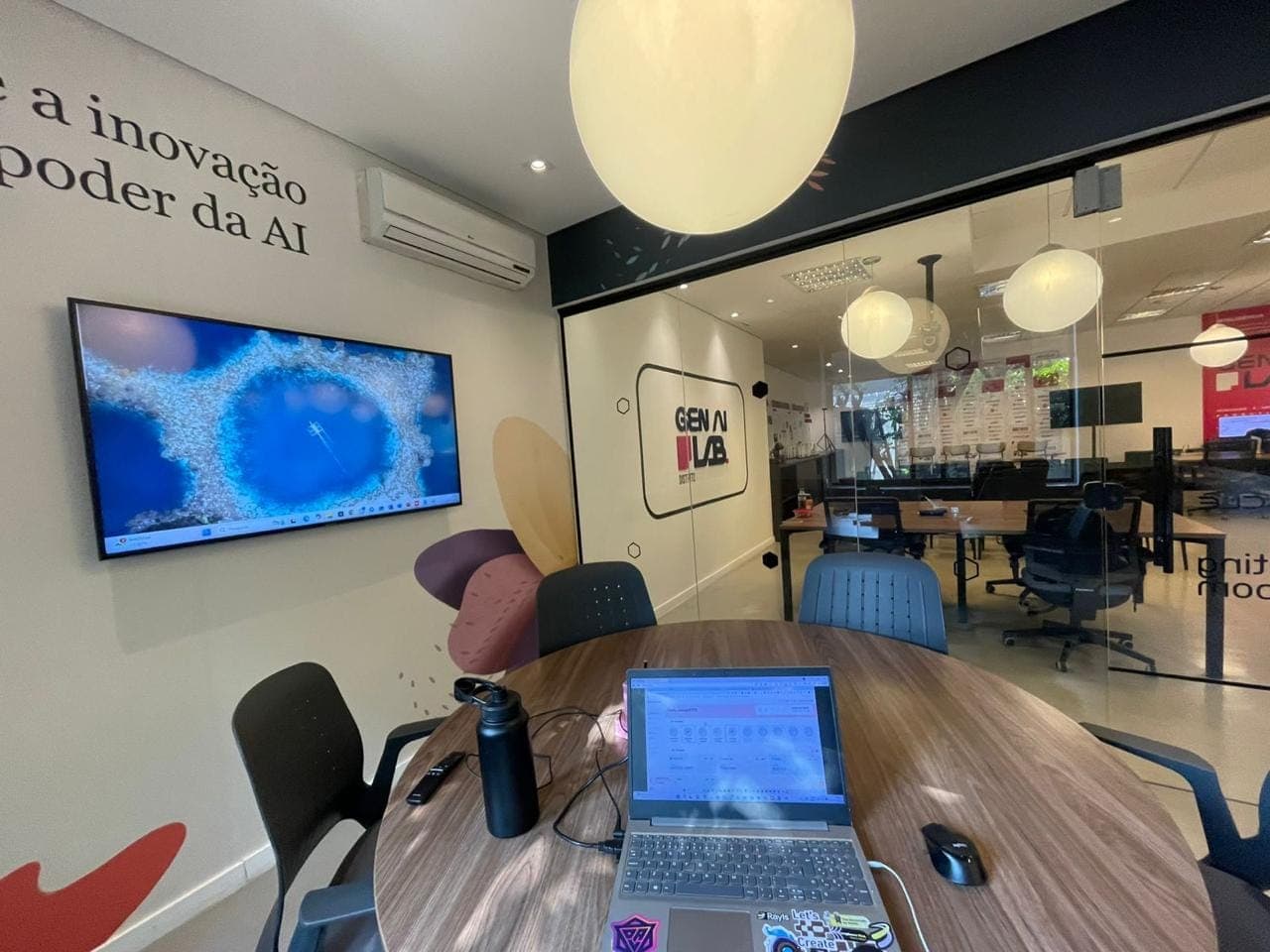 Sala de trabalho com notebook no Gen AI Lab do Distrito